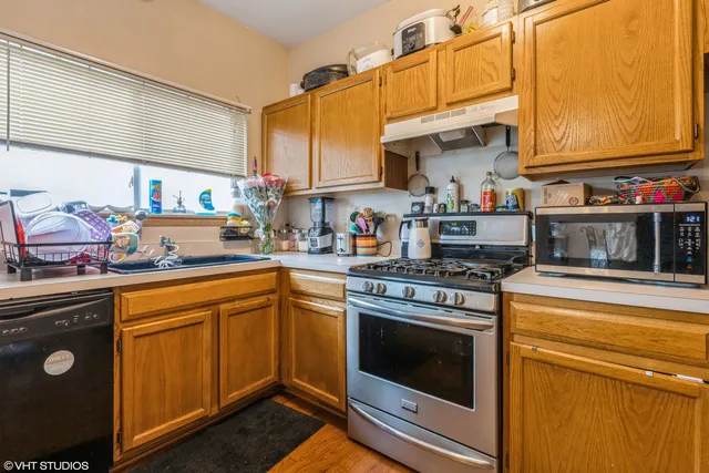 a kitchen with stainless steel appliances granite countertop a stove a sink and cabinets