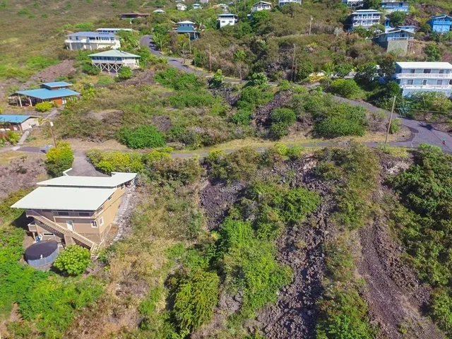 an aerial view of residential house with outdoor space and trees all around