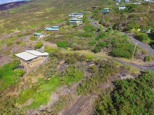 an aerial view of residential house with outdoor space and trees all around