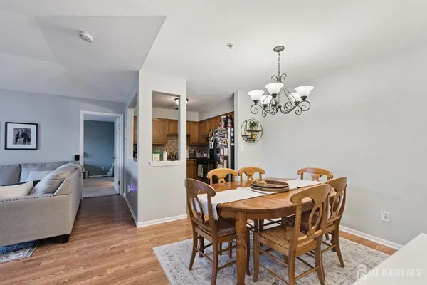 a dining room with furniture wooden floor a rug and a chandelier