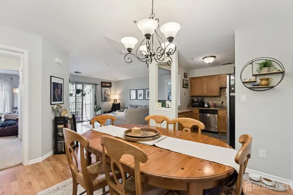 a view of a dining room with furniture a chandelier and wooden floor