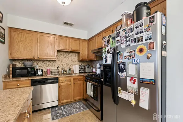 a kitchen with stainless steel appliances granite countertop a stove a sink and a refrigerator