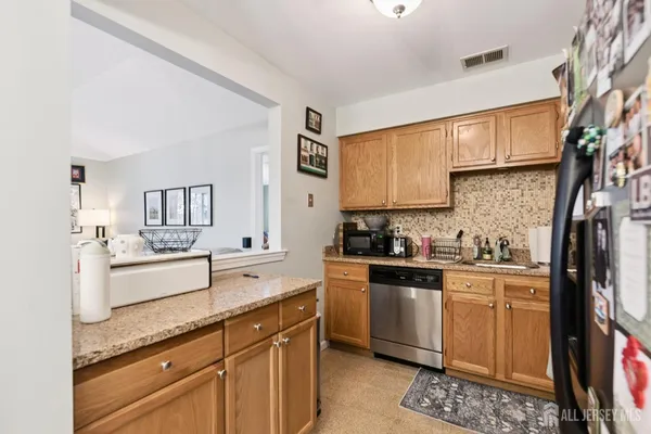 a kitchen with stainless steel appliances a sink cabinets and wooden floor