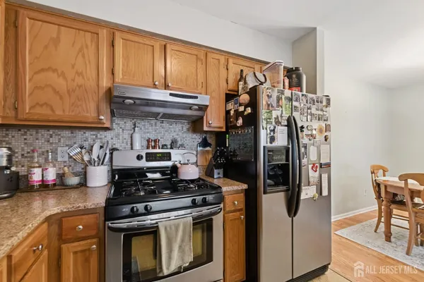 a kitchen with stainless steel appliances granite countertop a stove and a refrigerator