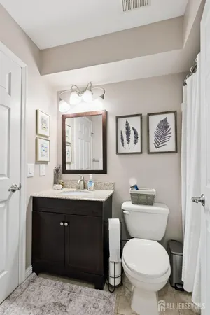 a bathroom with a toilet sink and mirror