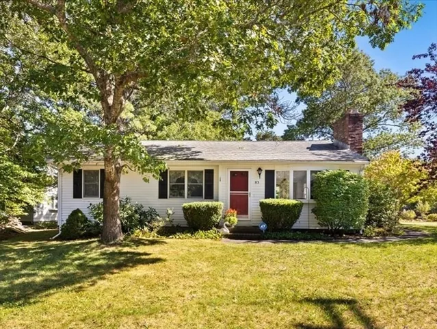 a front view of house with yard and trees around