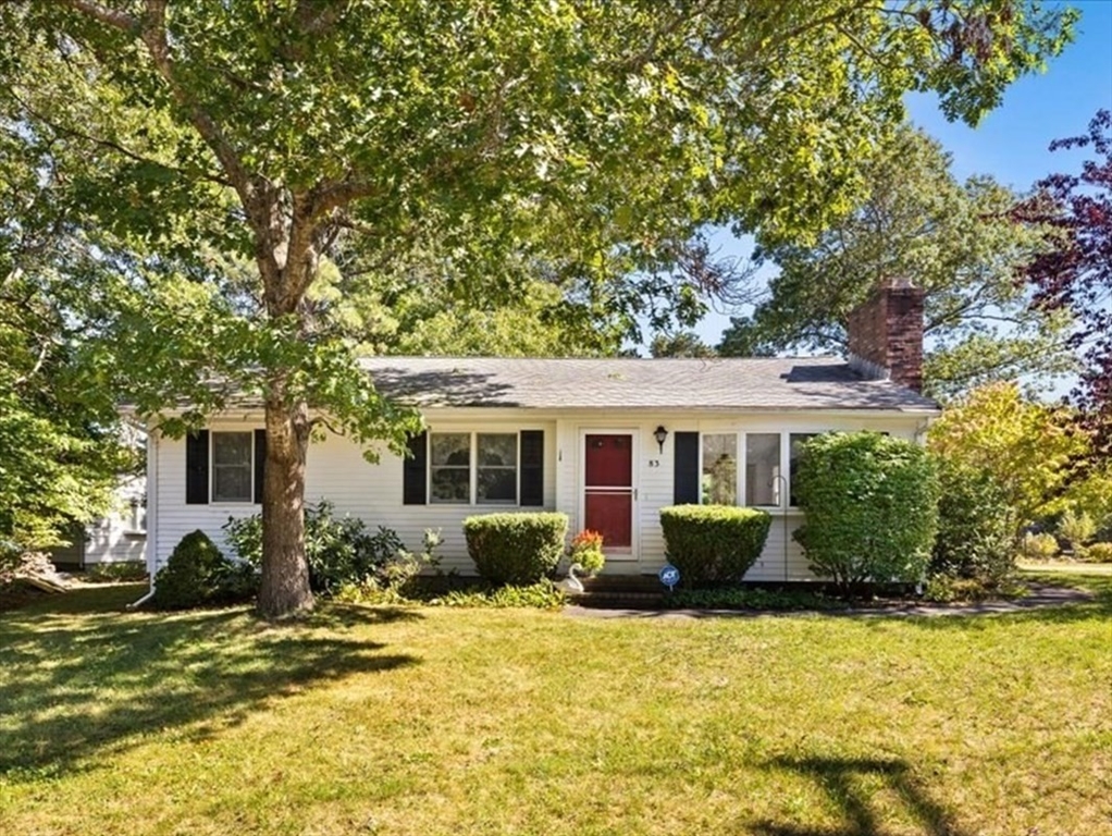 a front view of house with yard and trees around