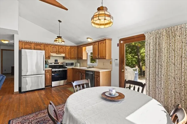 a kitchen with a refrigerator coffee maker a sink and a dining table