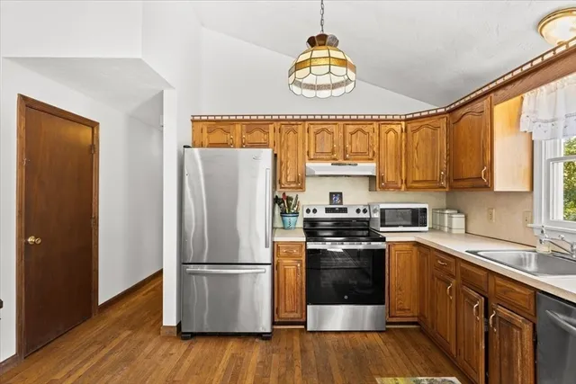 a kitchen with a refrigerator a stove a sink and a window