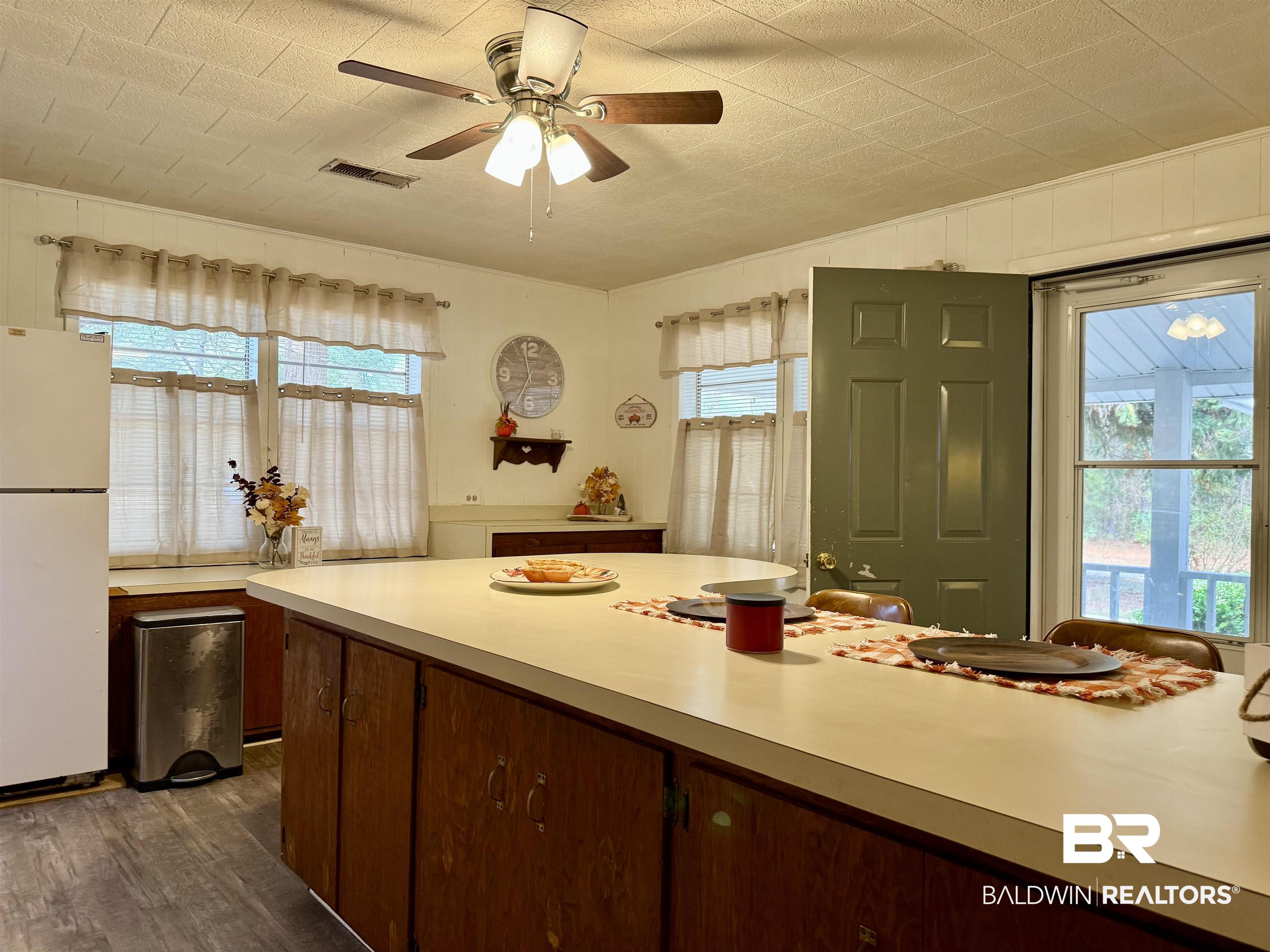 826 West Side Road Castleberry, AL 36432 - Photo 5 of 34 Kitchen with freestanding refrigerator, light countertops, plenty of natural light, and dark wood-type flooring