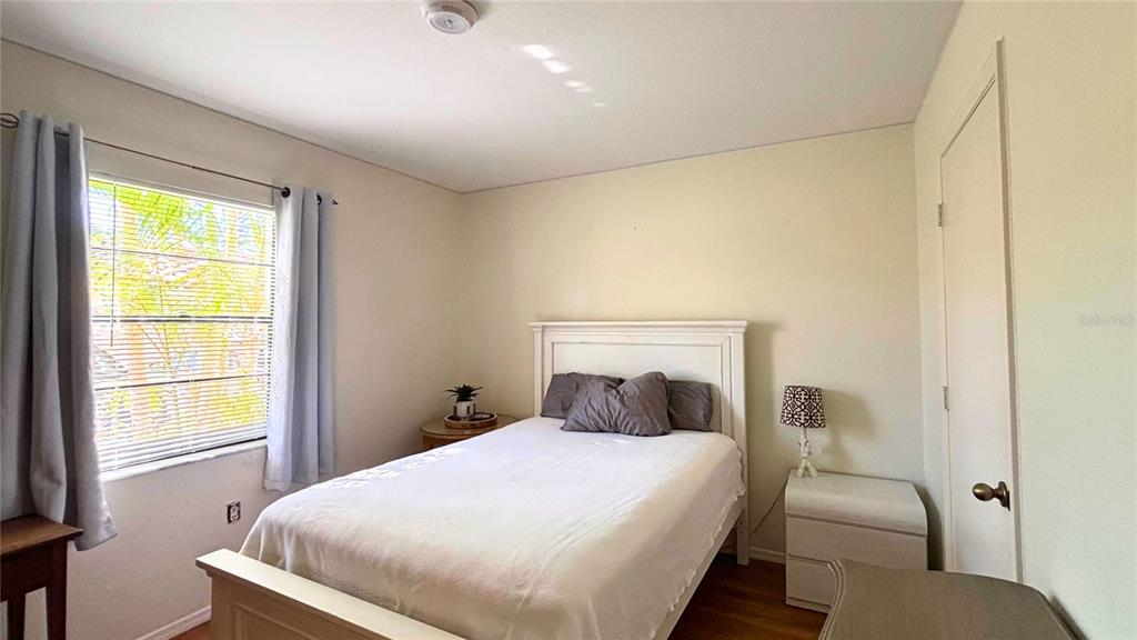 2275 South McCall Road, Unit 103 Englewood, FL 34224 - Photo 12 of 17 a bedroom with a bed and wooden floor