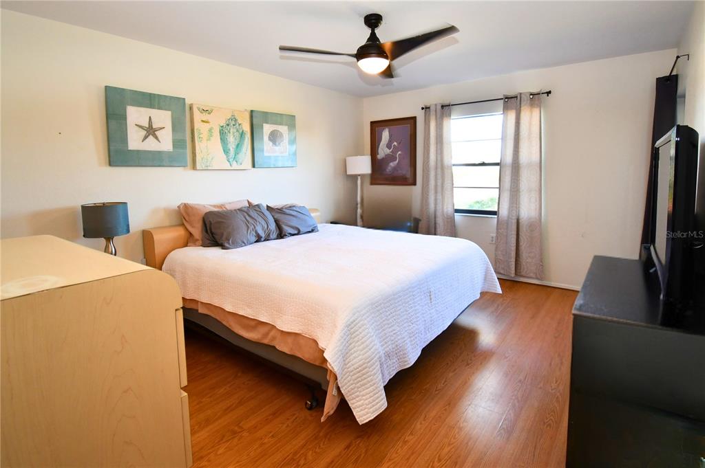 2275 South McCall Road, Unit 103 Englewood, FL 34224 - Photo 7 of 17 a bedroom with a bed and a flat screen tv