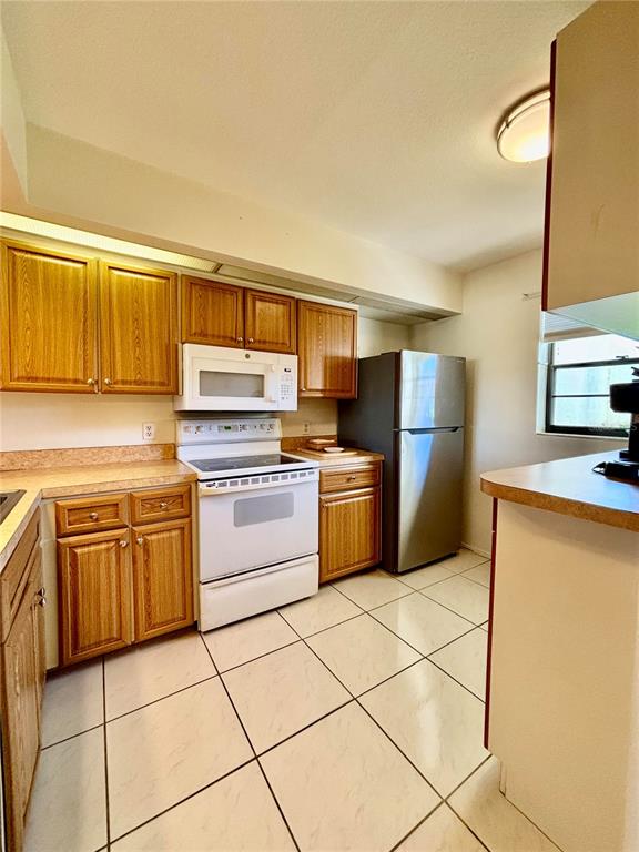 2275 South McCall Road, Unit 103 Englewood, FL 34224 - Photo 9 of 17 a kitchen with a stove top oven sink and cabinets