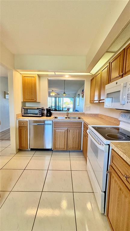 2275 South McCall Road, Unit 103 Englewood, FL 34224 - Photo 10 of 17 a kitchen with stainless steel appliances granite countertop a stove a sink and a refrigerator