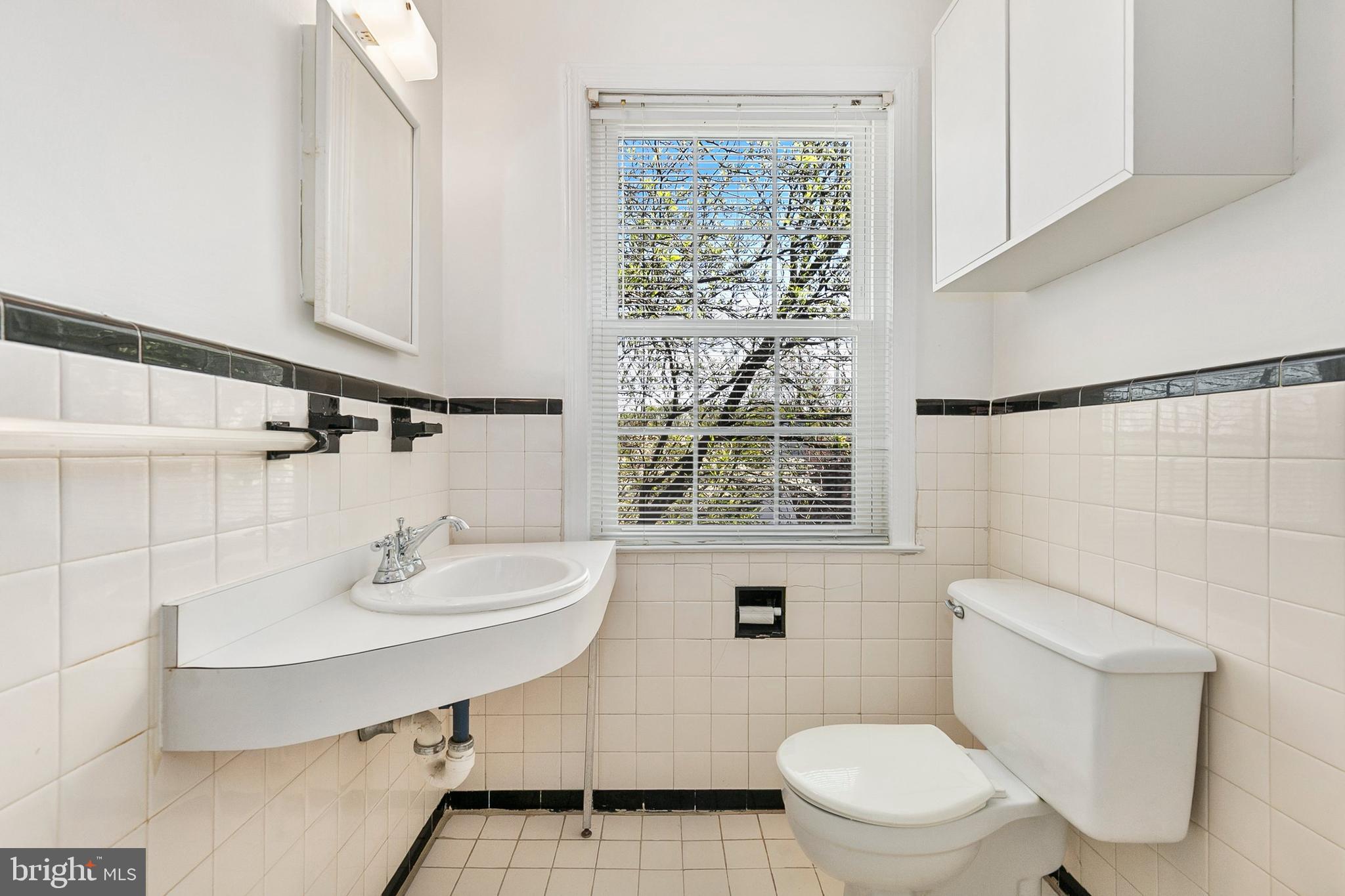 2211 Washington Avenue, Unit 303 Silver Spring, MD 20910 - Photo 11 of 28 a bathroom with a sink toilet a mirror and shower