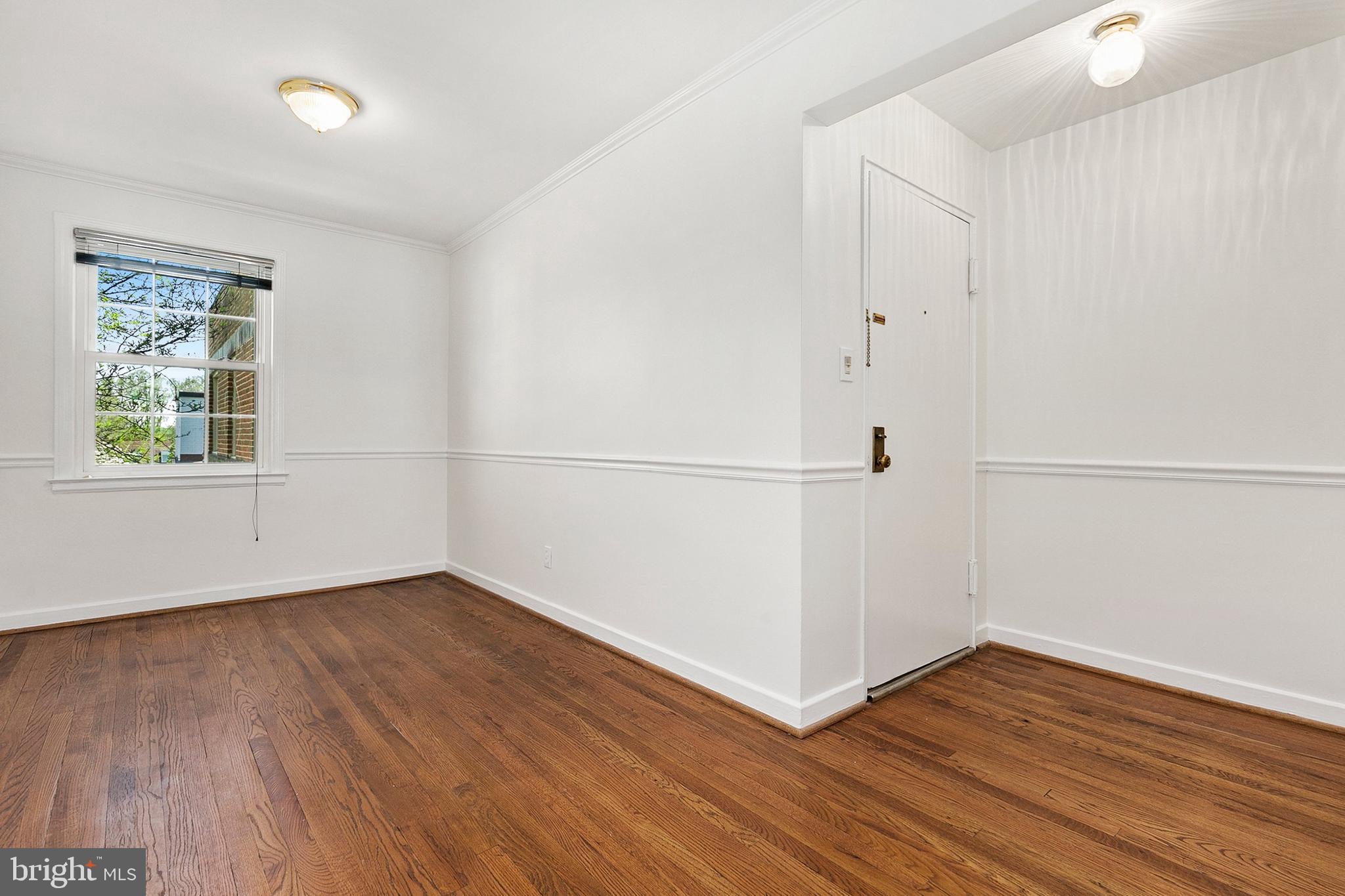 2211 Washington Avenue, Unit 303 Silver Spring, MD 20910 - Photo 14 of 28 an empty room with wooden floor and windows