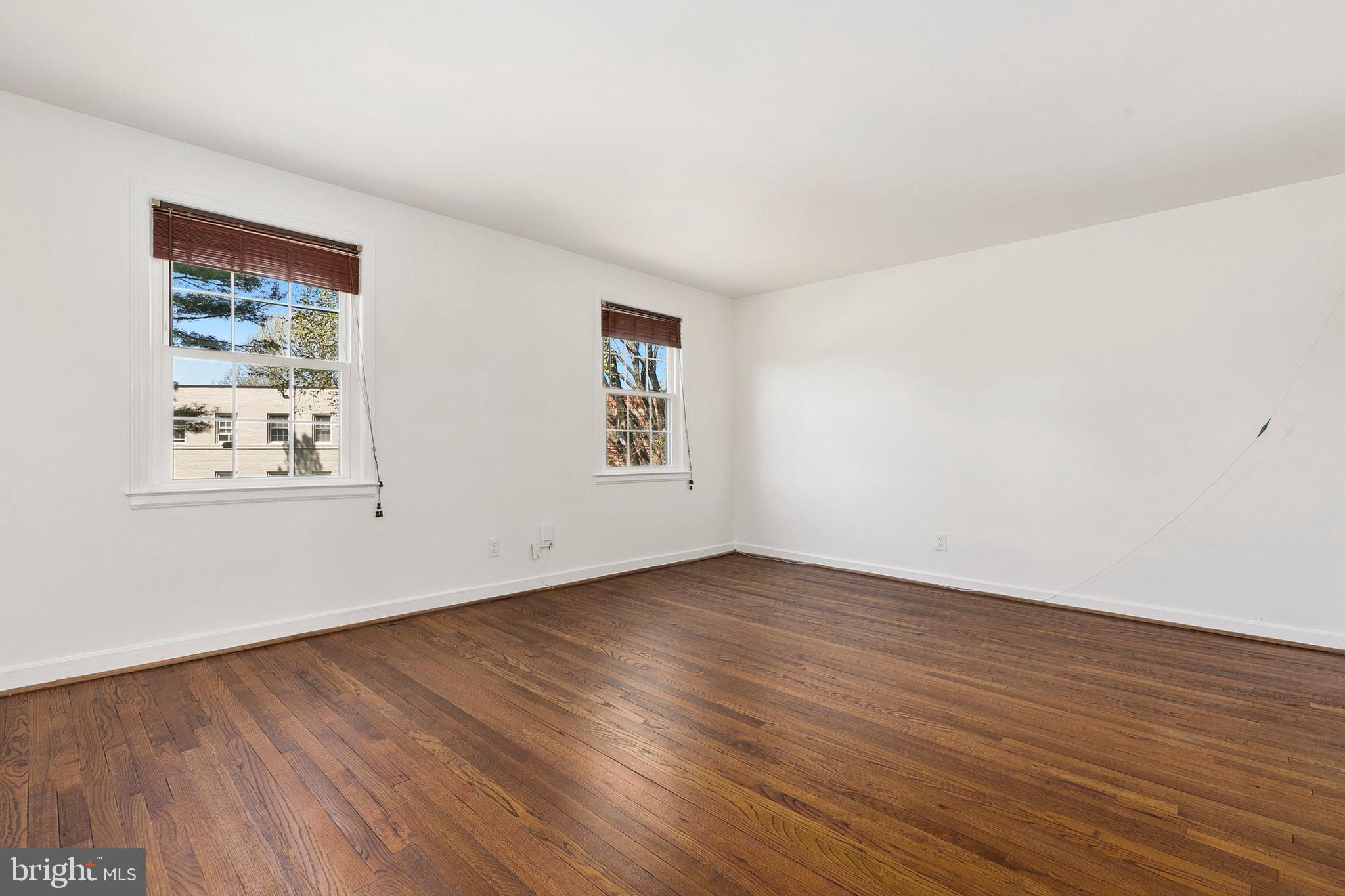 2211 Washington Avenue, Unit 303 Silver Spring, MD 20910 - Photo 15 of 28 a view of an empty room with wooden floor and a window