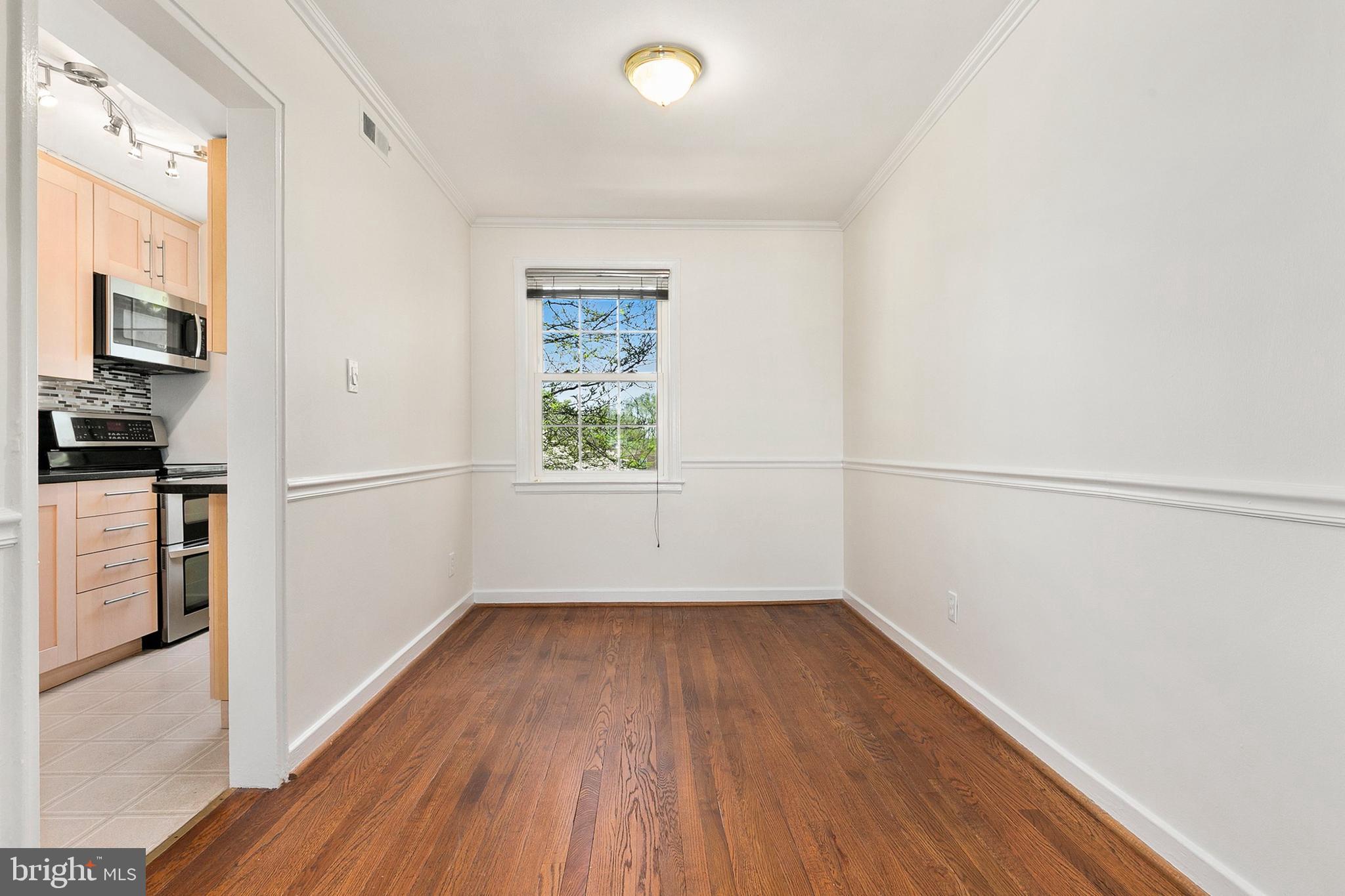 2211 Washington Avenue, Unit 303 Silver Spring, MD 20910 - Photo 17 of 28 a view of empty room with wooden floor and window