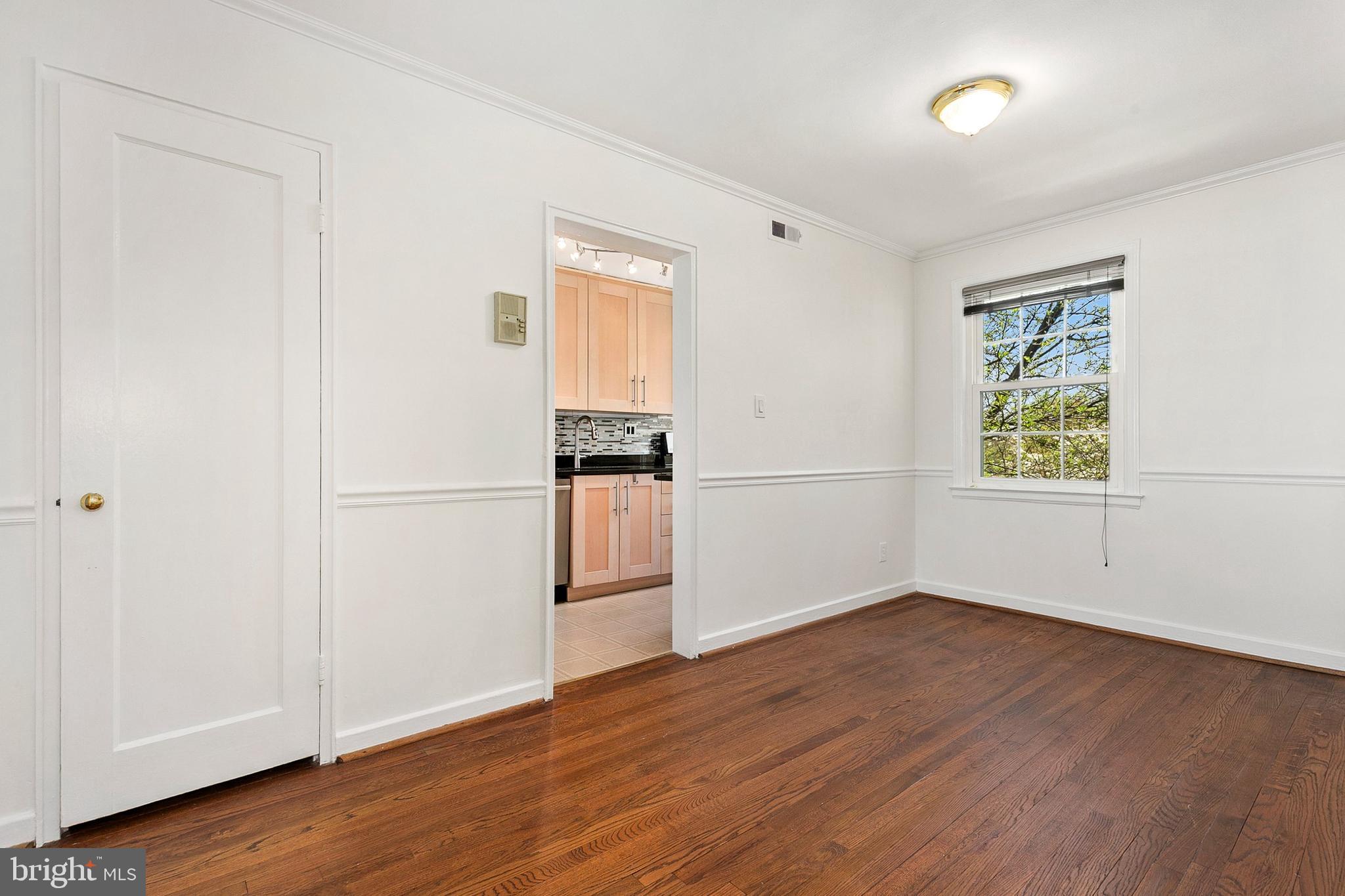 2211 Washington Avenue, Unit 303 Silver Spring, MD 20910 - Photo 18 of 28 an empty room with wooden floor cabinet and windows