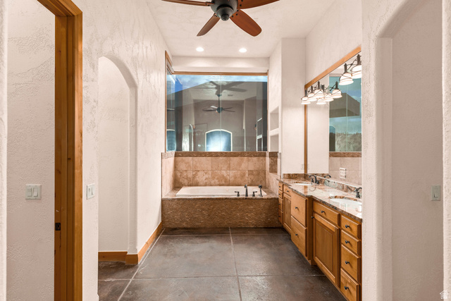 2464 East Granite Way St. George, UT 84790 - Photo 32 of 106 Primary bathroom with a textured wall, ceiling fan, double vanity, a garden tub, and a shower stall