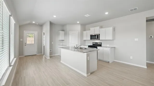 a kitchen with stainless steel appliances granite countertop a sink and a stove