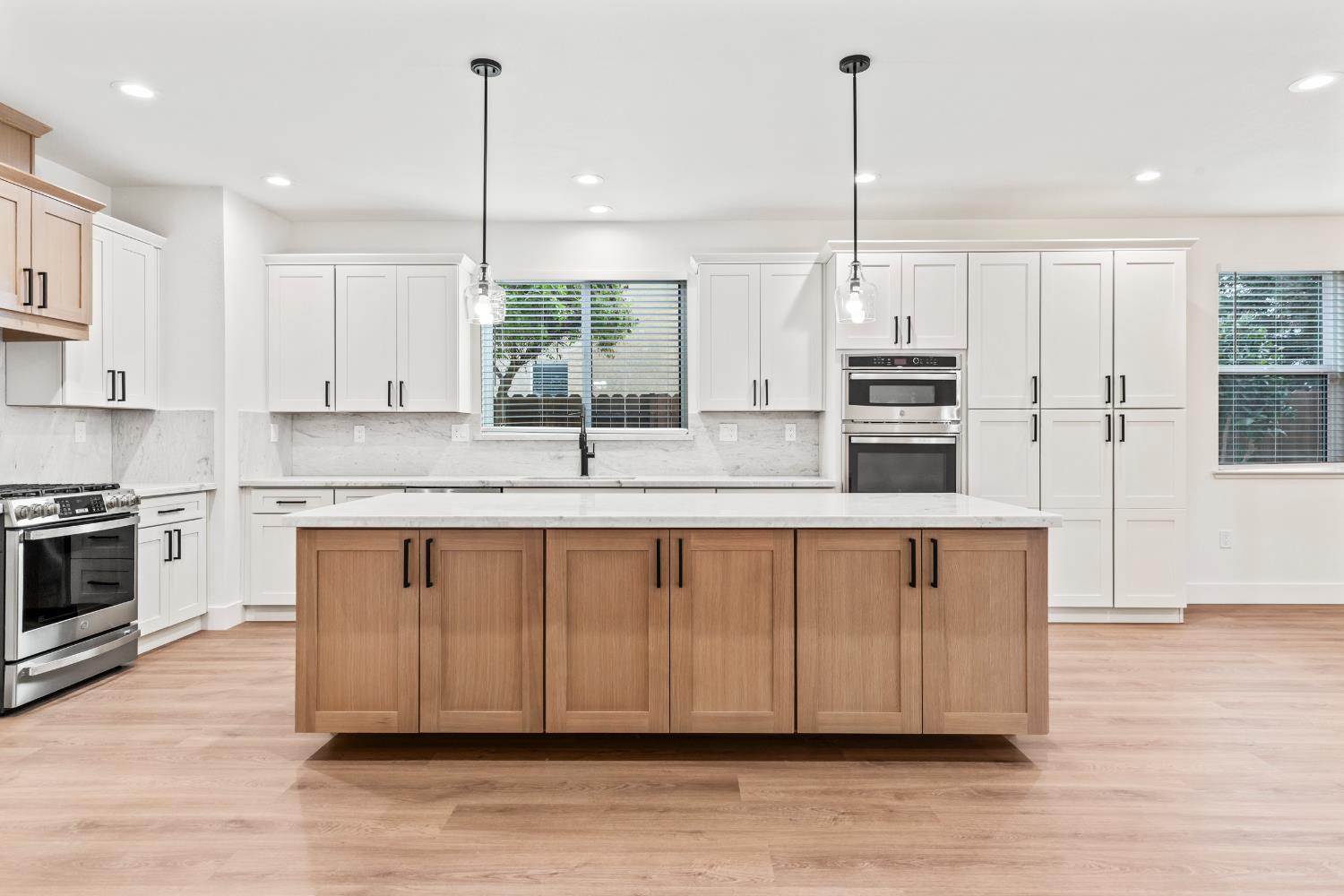 688 Cindy Drive Ripon, CA 95366 - Photo 11 of 57 a kitchen with stainless steel appliances granite countertop a sink a stove a refrigerator a center island and cabinets with wooden floor