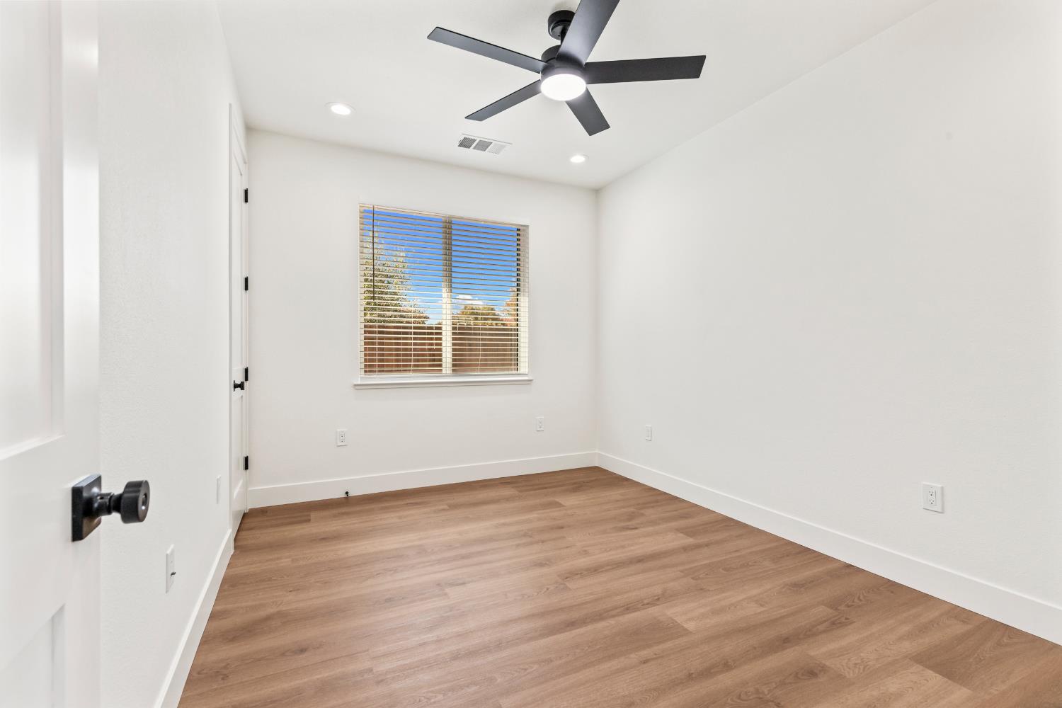 688 Cindy Drive Ripon, CA 95366 - Photo 18 of 57 an empty room with wooden floor fan and windows