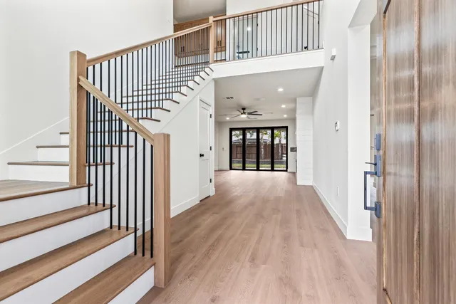 a view of a hallway with wooden floor and staircase