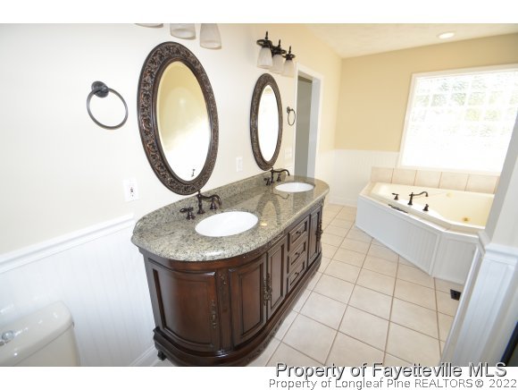 2651 Blossom Road Hope Mills, NC 28348 - Photo 21 of 25 a bathroom with a sink a mirror and a sink