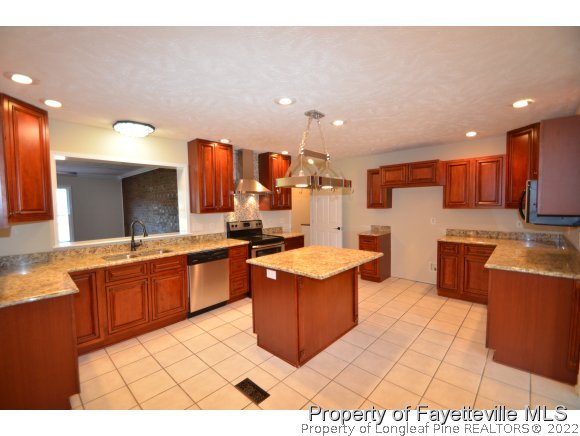 2651 Blossom Road Hope Mills, NC 28348 - Photo 7 of 25 a large kitchen with stainless steel appliances a stove a sink dishwasher and a refrigerator