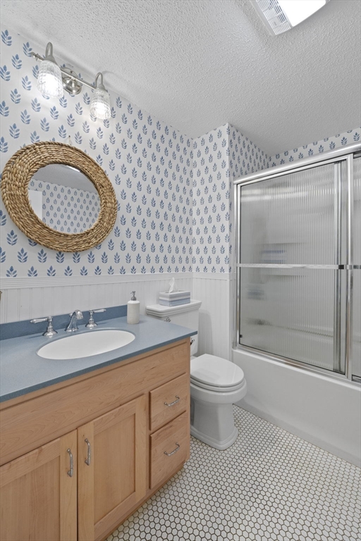 121 Water Street, Unit 44 Beverly, MA 01915 - Photo 11 of 24 a bathroom with a granite countertop toilet a sink and a mirror