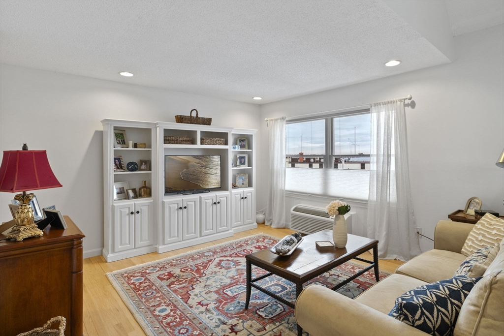 121 Water Street, Unit 44 Beverly, MA 01915 - Photo 4 of 24 a living room with furniture and a flat screen tv