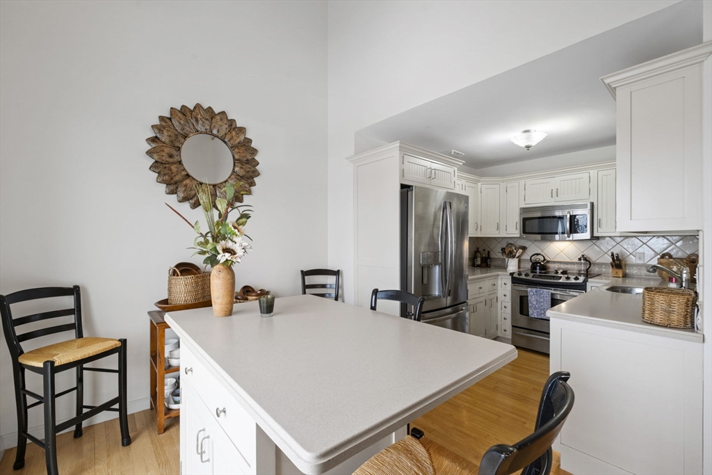 121 Water Street, Unit 44 Beverly, MA 01915 - Photo 7 of 24 a very nice looking dining room with kitchen island stainless steel appliances a sink counter space and furniture
