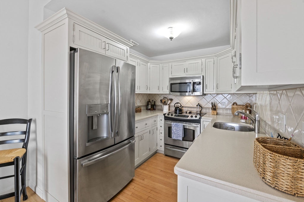 121 Water Street, Unit 44 Beverly, MA 01915 - Photo 8 of 24 a kitchen with granite countertop stainless steel appliances and wooden cabinets