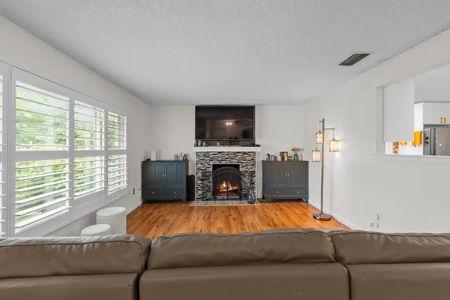 a living room with furniture a fireplace and a flat screen tv