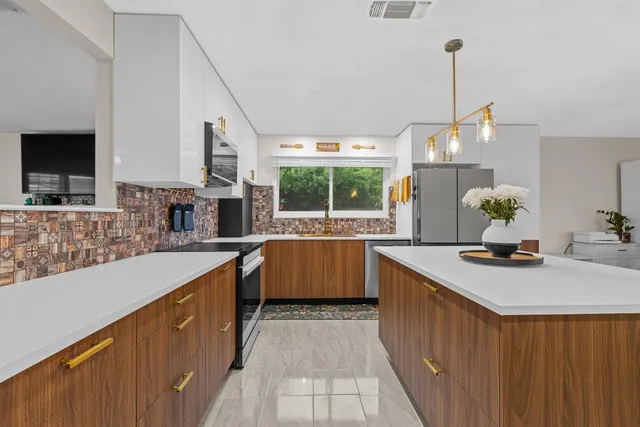 a kitchen with stainless steel appliances a sink stove and wooden cabinets