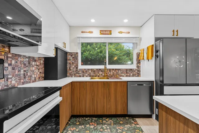 a kitchen with stainless steel appliances granite countertop a refrigerator and a stove