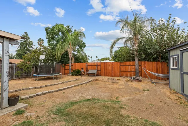 a backyard of a house with table and chairs