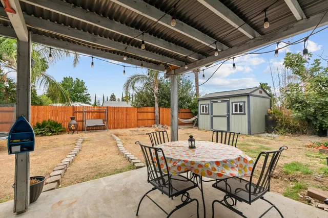 a view of a patio with table and chairs with wooden floor and fence
