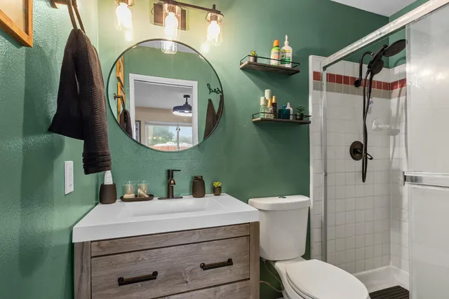 a bathroom with a toilet a sink and mirror