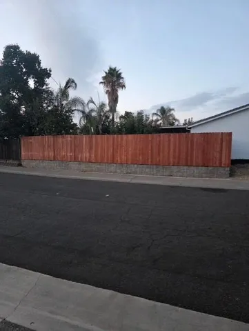 a view of backyard with wooden fence