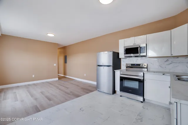 a kitchen with a refrigerator and a stove top oven