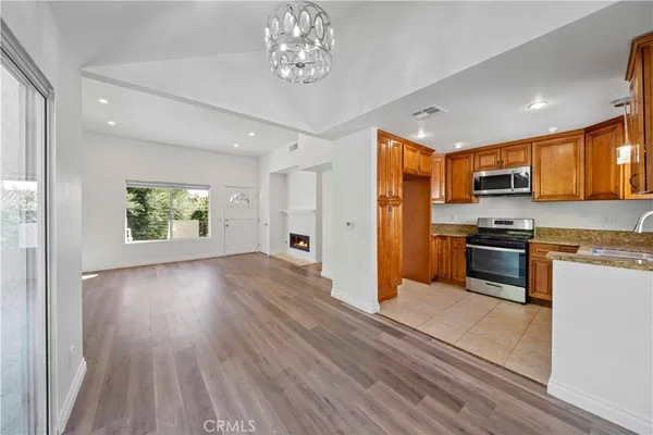 a kitchen with granite countertop stainless steel appliances a stove top oven a sink and cabinets