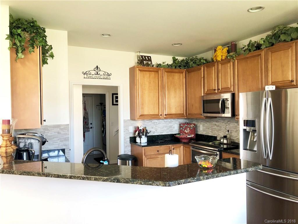 277 Yadkin Road Fletcher, NC 28732 - Photo 6 of 15 a kitchen with kitchen island granite countertop a sink appliances cabinets and a counter top space