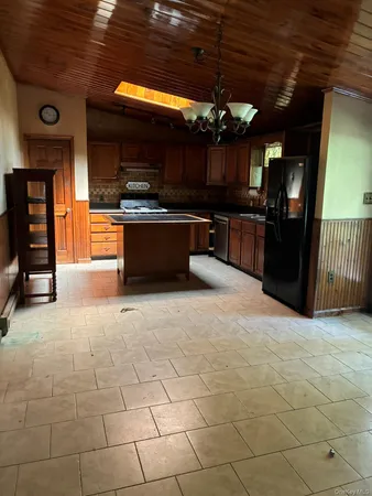 a kitchen with stainless steel appliances kitchen island granite countertop a stove and a cabinets