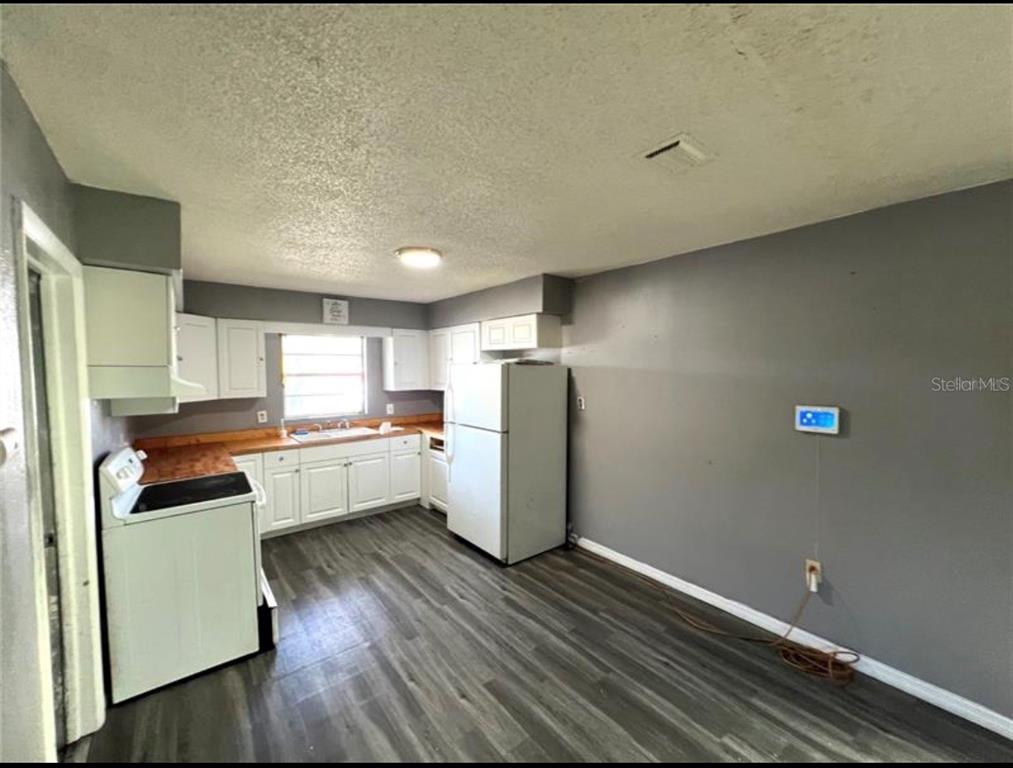 7004 Clarcona Ocoee Road Orlando, FL 32818 - Photo 3 of 10 a kitchen that has a fridge and wooden floor