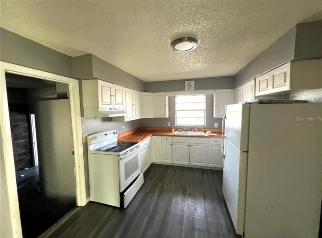 7004 Clarcona Ocoee Road Orlando, FL 32818 - Photo 4 of 10 a kitchen with a refrigerator a sink and wooden floor