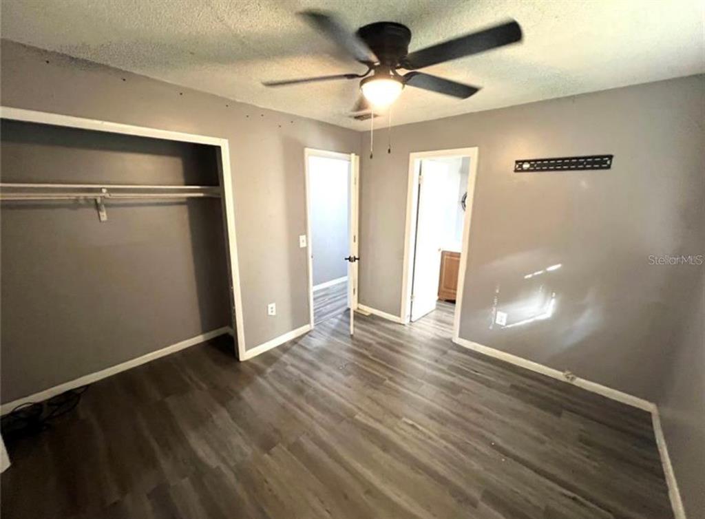 7004 Clarcona Ocoee Road Orlando, FL 32818 - Photo 5 of 10 a view of empty room with wooden floor and fan