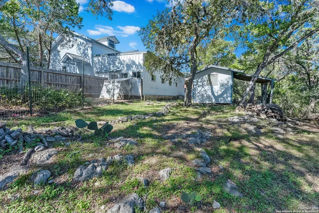 a view of a house with backyard and trees