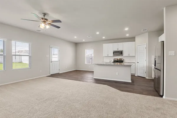 a kitchen with stainless steel appliances granite countertop a stove a sink and a microwave